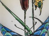 a close up of a vase with flowers and a butterfly on it