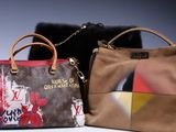 Deux sacs à main Louis Vuitton, l'un marron et l'autre rouge, sont posés sur une surface blanche.