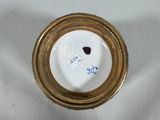 a white and gold vase with a gold rim on a white table