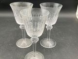 four clear wine glasses sitting on top of a table