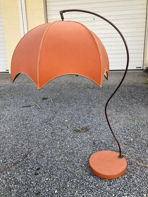 an orange umbrella that is on a metal stand