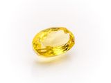 a yellow sapphire stone on a white background