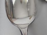a silver spoon with a spoon handle on a table