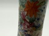 a vase with a floral design on it sitting on a table