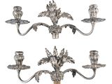 un ensemble de trois chandeliers en métal argenté ornés de fleurs et de feuilles