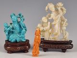 trois figurines chinoises sculptées représentant une femme et un homme, posées sur un socle