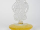 an image of a yellow glass vase with a carved face on it
