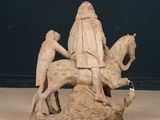 a statue of a man riding a horse with a man on it