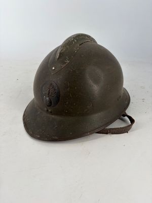 un vieux casque troué posé sur une surface blanche