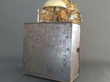 a silver box with a gold object on top of it