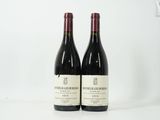 deux bouteilles de vin rouge posées sur une table blanche