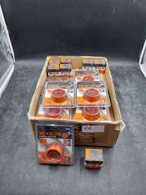 une boîte de ruban adhésif orange posée par terre à côté d'une boîte de ruban adhésif orange