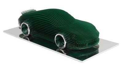 une voiture verte en papier posée sur une assiette