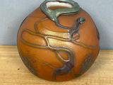 a brown vase sitting on top of a wooden table