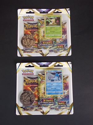 deux paquets de cartes à collectionner Pokémon posés sur une surface noire
