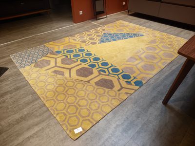 yellow and blue area rug in a living room with wooden flooring
