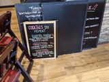 tables and chairs in a restaurant with menus on the wall