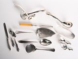de nombreuses cuillères, fourchettes et cuillères-fourchettes disposées sur une table