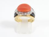 a close up of a ring with an orange stone and diamonds