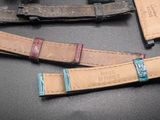 three different colored leather straps on a black surface