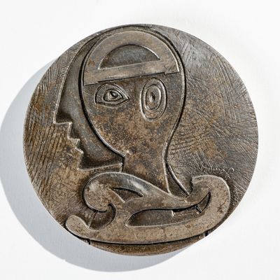 une plaque métallique sur laquelle figure l'image d'une femme