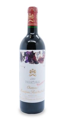 a bottle of red wine sitting on top of a white table