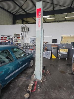 une voiture bleue garée dans un garage à côté d'un poteau