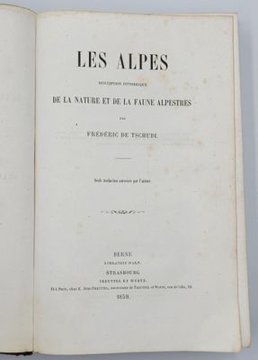 un livre ouvert posé sur une table à côté d'une tasse de café