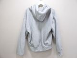 grey hoodie on a hanger against a white wall