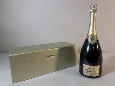 une bouteille de champagne à côté d'un coffret sur une table