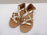 the gold sandals are on a white surface, ready to be worn