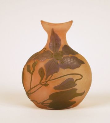 a small vase with a flower on it on a white surface