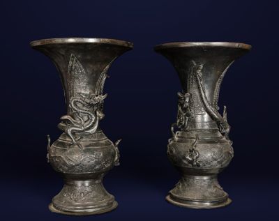 two vases that are sitting on a blue surface