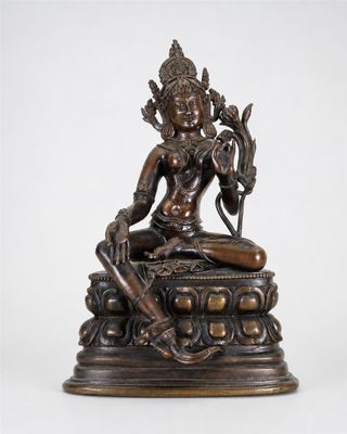 une statue en bronze représentant une femme assise sur une table