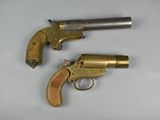 two old revolvers sitting on a white surface with a keychain