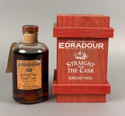 une bouteille de whisky posée à côté d'une caisse en bois