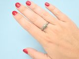 woman ' s hand with red manicured nails and a diamond ring