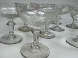 several empty wine glasses are lined up on a white table