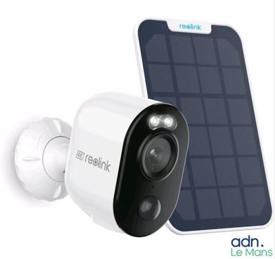 a close up of a solar powered security camera next to a cell phone