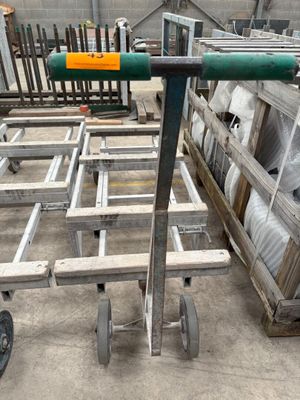 a cart with a green handle sitting in a warehouse