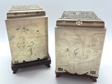 deux boîtes en argent ornées de motifs, posées sur une table