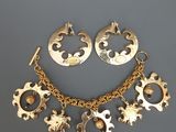 un gros plan d'un collier et de boucles d'oreilles posés sur une surface grise