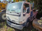 a truck that is sitting in the grass with a bulldozer behind it