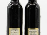 two bottles of olive oil are sitting on a white surface