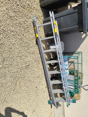 a ladder leaning up against a building next to a trash can