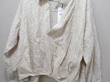 the white shirt is hanging on a hanger on the wall