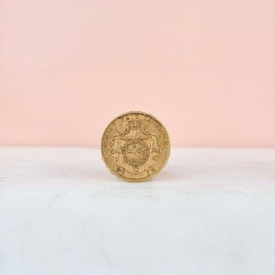 a gold coin sitting on top of a white surface