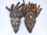 two wooden masks are sitting next to each other on a white surface