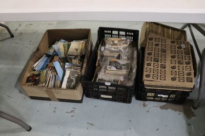Plusieurs cartons contenant des objets divers sont posés sur une table devant une chaise.