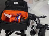 un sac noir contenant des objets orange, posé sur un bureau